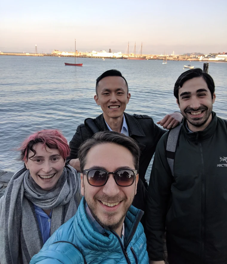 Four people smiling for a selfie by the water in San Francisco
